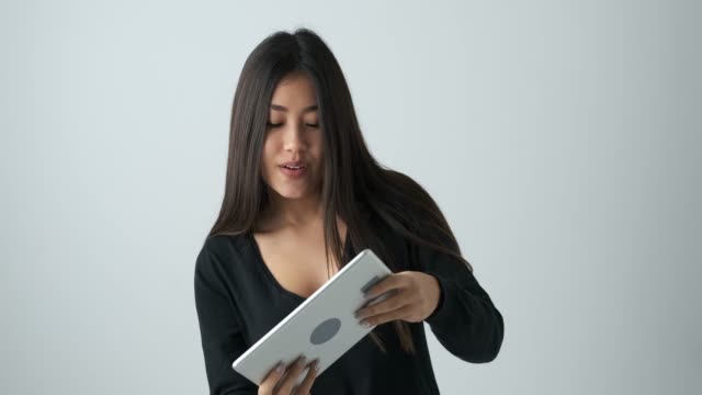 Mujer-asiática-jugando-juegos-en-la-tableta-digital