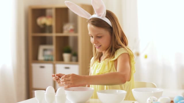 girl-coloring-easter-eggs-by-liquid-dye-at-home
