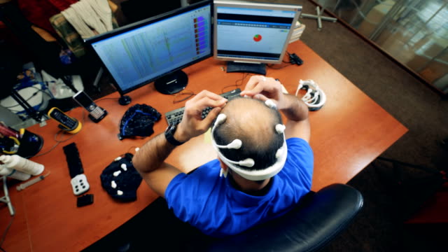 Draufsicht-eines-Mannes-sitzen-und-ein-Bio-Signal-EEG-Kopfhörer-aufsetzen