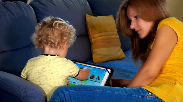 niña-de-niño-con-la-madre-jugando-en-la-computadora-de-la-tableta.