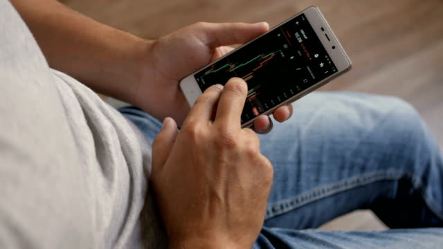 Businessman-reading-financial-news.-Stock-market,-trading-online,-trader-working-with-smartphone-on-stockmarket-trading-floor.-Man-touching-screen,-browse-foreign-exchange-market-data,-chart.-Forex.
