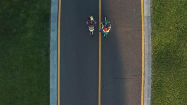 Drone-shot-of-gay-couple-biking-along-bicycle-path