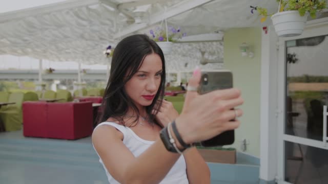 Schöne-Frau-macht-Selfie-auf-der-Veranda-des-Restaurants