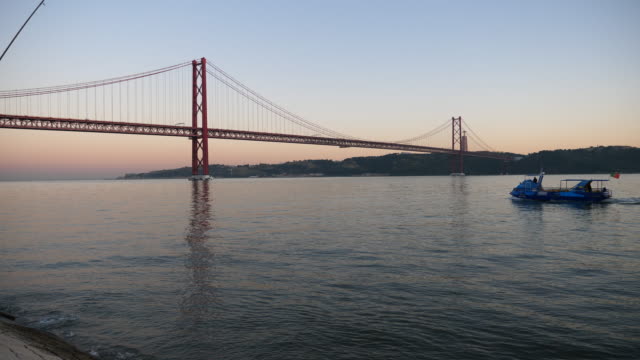 Sonnenuntergang-sausen-die-Brücke-Lissabon-mit-Boot-Portugal