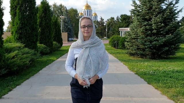 Mujer-ortodoxa-caminando-en-el-Parque-en-el-fondo-de-la-Iglesia
