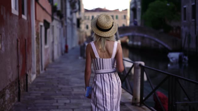 Positive-weibliche-Reisende-erholt-sich-während-des-italienischen-Sommerwochenendes-in-Venedig