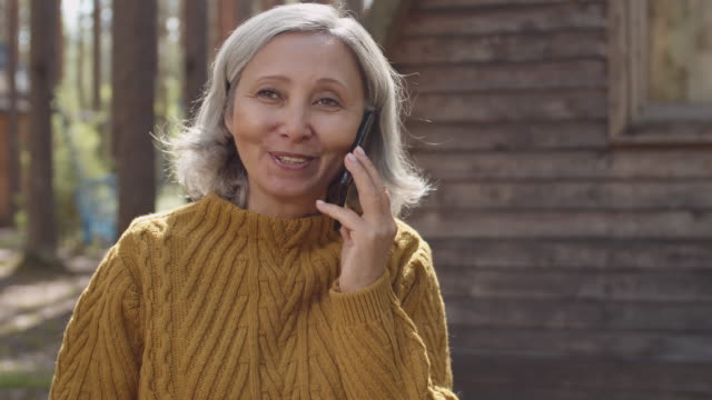 Ältere-Frau-spricht-am-Telefon-in-Touristenlager