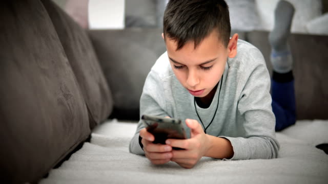 Cute-little-boy-watching-cartoons-on-mobile-phone