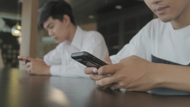 Hombres-jóvenes-que-utilizan-el-teléfono-inteligente-para-chatear-en-línea.