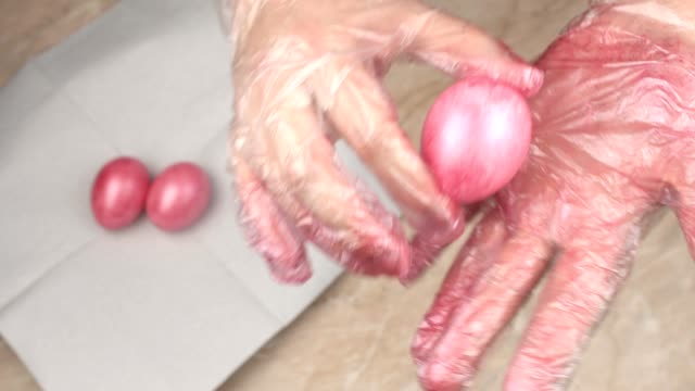 A-girl-paints-chicken-eggs-in-pink-pearly-color-for-the-holiday-Easter,-close-up,-preparation,-decoration