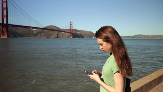 Mujer-usando-smartphone-junto-al-puente-Golden-Gate