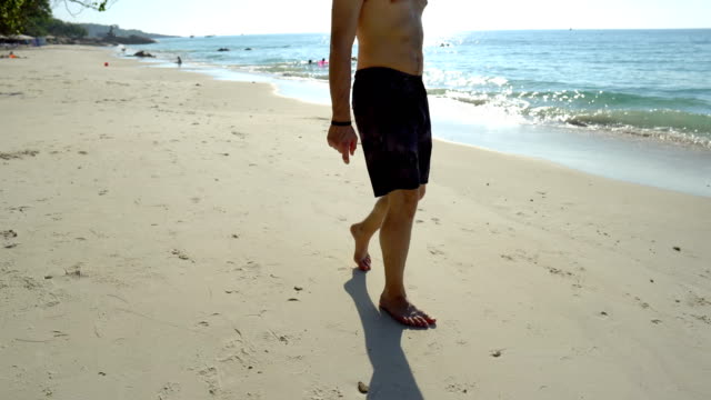 Junge-Homosexuell-Mann-in-Liebe-zu-Fuß-auf-tropischen-Strand-und-Ziehen-Herz-im-Sand-für-Freund