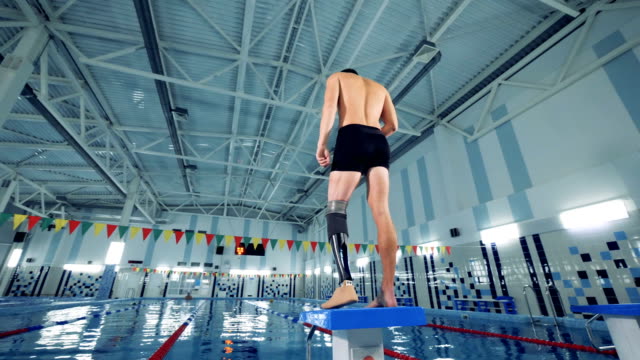 Swimming-pool-and-a-man-with-a-robotic-leg-warming-up