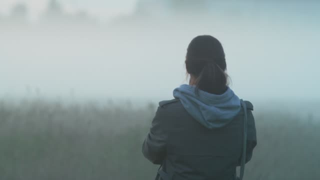 Ein-Mädchen-steht-auf-einem-Feld-und-schießt-den-Nebel-auf-ein-Smartphone