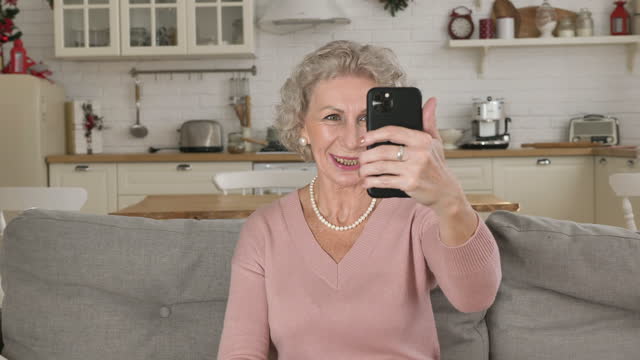 Rentnerin-spricht-und-lächelt-in-Smartphone-Kamera