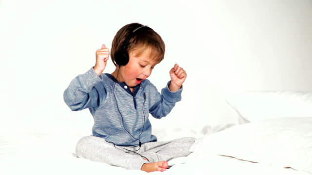 4-year-old-boy-in-bed-with-headphones-playing-with-the-tablet