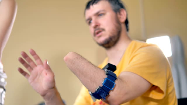 Disabled-man-with-the-amputated-arm.-Wireless-sensor-for-bionic-prosthesis-control-on-his-stump.-4K.
