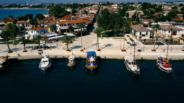 Aerial-travel-video-view-of-old-city-with-yacht-and-boats-at-marina-in-front-of-it.-Waterfront,-ocean-river-marina-port-dock,-boats-ships