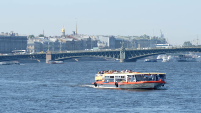 Tour-boat-moves-on-the-Neva-river-on-city-background-in-the-summer---St.-Petersburg,-Russia