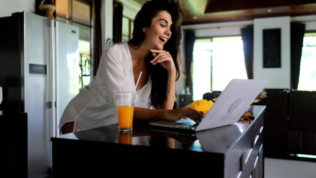 Girl-Use-Laptop-Computer-In-Kitchen-Chatting-Online-Young-Woman-Drink-Juice-Studio-Modern-House-Interior