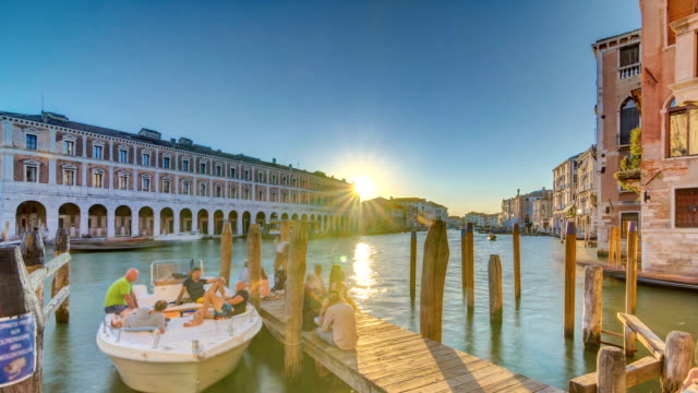 Visión-del-mercado-de-Rialto-desierta-en-timelapse-atardecer,-visto-desde-el-muelle-a-través-del-Gran-Canal-de-Venecia,-Italia