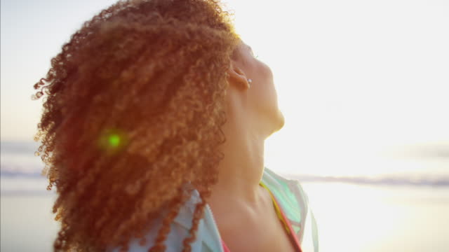 African-American-female-enjoying-ocean-sunrise-in-summer