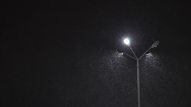Bei-Nacht-beleuchtete-Laterne-schneit