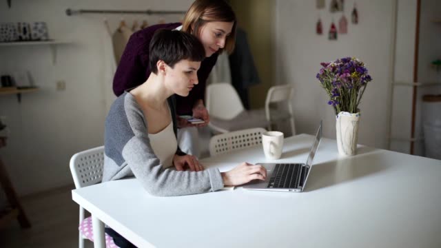 Female-students-searching-internet-on-laptop-computer.-Two-woman-looking-news
