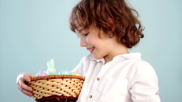 Boy-with-Easter-basket.-Teenager-shows-on-his-outstretched-hand-a-gently-blue-Easter-egg