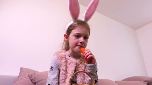 Niña-con-orejas-de-conejo-comiendo-zanahoria