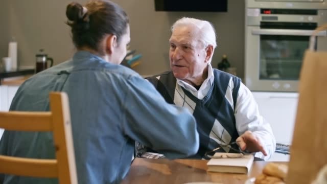 Hombre-joven-ayudando-a-anciano-con-cuentas-hogar