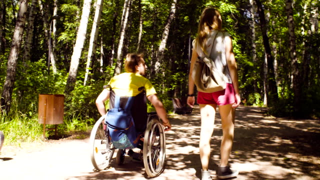 Young-disable-man-with-his-wife-on-a-walk-in-the-park