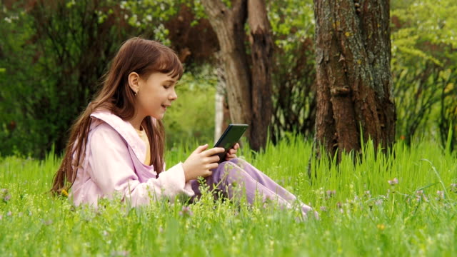 Video-call.-A-child-with-a-tablet-in-the-grass