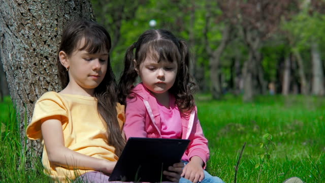 Niños-con-una-tableta-sobre-la-naturaleza.