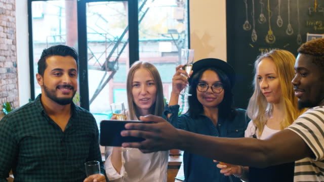 Multiethnische-Team-von-Designern,-die-unter-Selfie-mit-Sektgläser-auf-Betriebsfeier