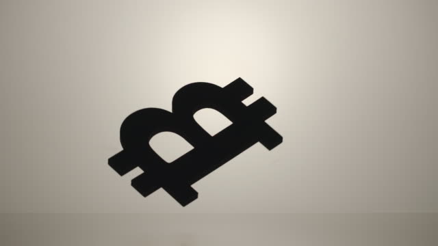 Zeitlupe:-Bitcoin-Zeichen-verdrehen-und-fallen-auf-die-weiße-Fläche