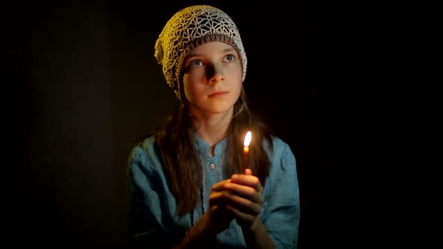 Mädchen-betet-in-einem-dunklen-Raum