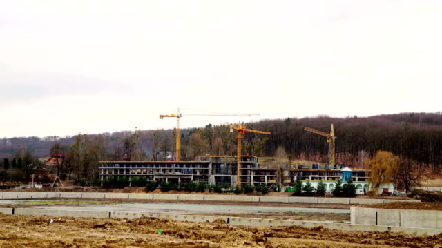 Timelapse-construction-industry.-Three-cranes-and-a-group-of-workers-are-building-a-house.