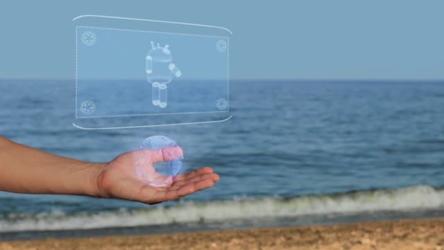 Manos-masculinas-en-la-playa-con-el-robot-moderno-holograma