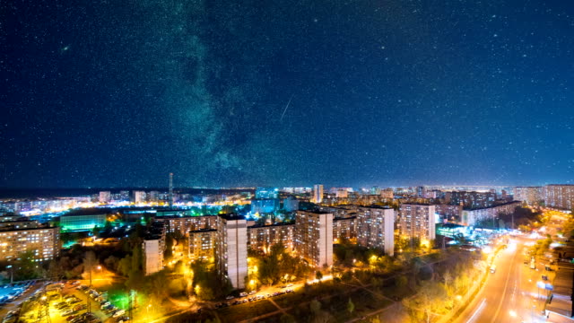The-picturesque-view-on-the-night-city-on-a-starry-sky-background.-time-lapse
