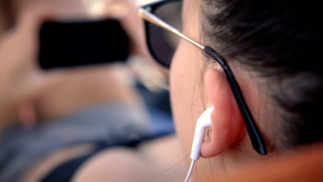 Guapa-adolescente-femenina-con-auriculares-viendo-la-película-en-el-ordenador-portátil,-enfoque-selectivo-cinemático