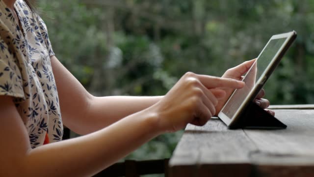 Mujer-asiática-joven-usando-la-tableta-en-la-cafetería.-Tecnología-de-redes-sociales.