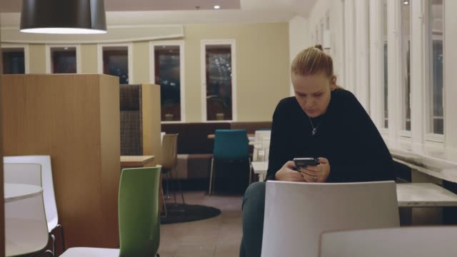 Mujer-sentada-sola-en-el-café-y-usando-el-móvil