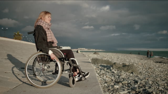 Einsame-behinderte-Frau-im-Rollstuhl-in-der-Nähe-des-Meeres