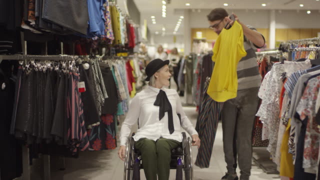 Mujer-en-silla-de-ruedas-comprando-ropa-con-grupo-de-amigos