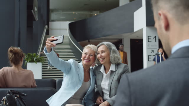 Zwei-Frauen-mittleren-Alters-machen-Selfie-am-Flughafen