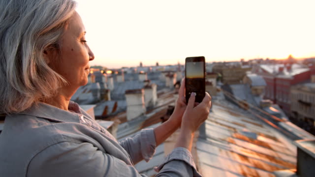 Grey-haired-Female-Tourist-Making-Photos-on-Roof
