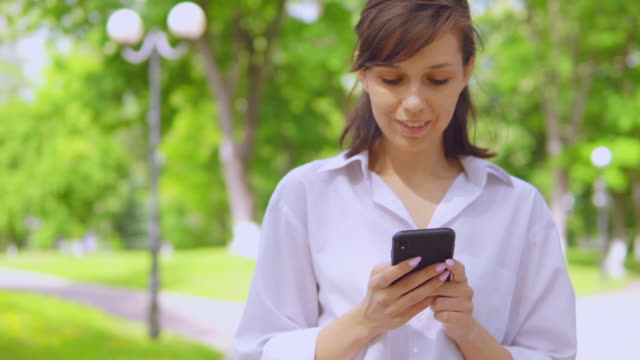 portrait-millennials-girl-chatting-online-use-cellphone-in-park