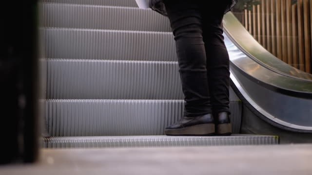 Piernas-de-personas-moviéndose-en-un-ascensor-de-escaleras-mecánicas-en-el-centro-comercial.-Pies-de-comprador-en-Escalera-Saltadora-en-el-Centro-Comercial