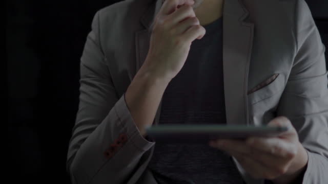 4K-Video-Nahaufnahme-Mann-Hand-in-Anzug-mit-Tablet-mit-schwarzem-Hintergrund.